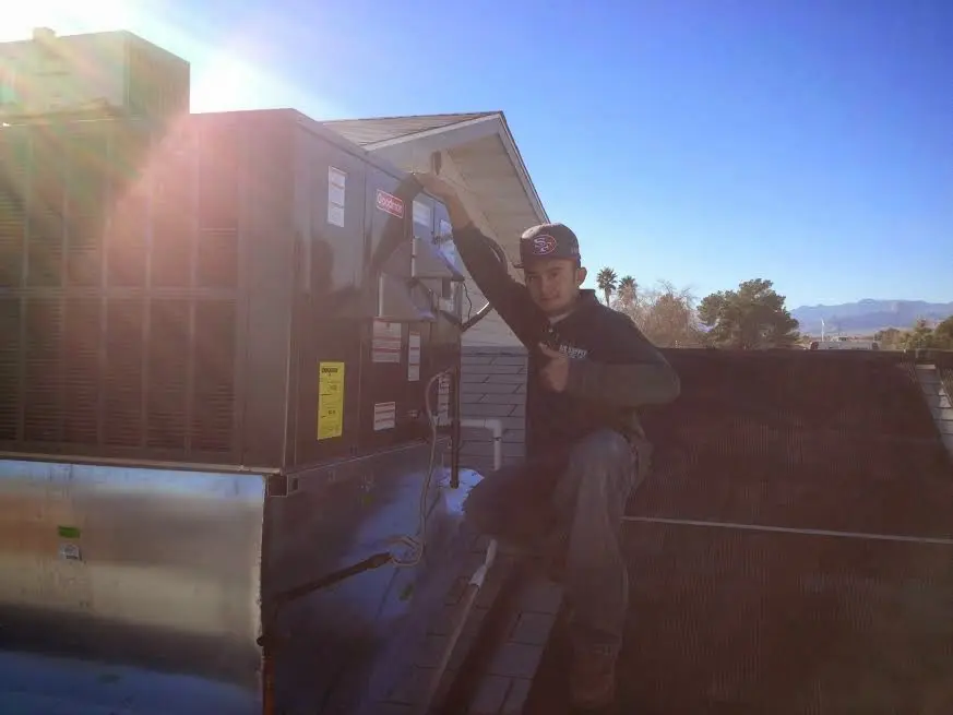 HVAC technician performing AC Tune-Up on a rooftop unit in Commerce